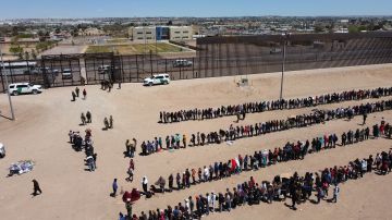 Inmigrantes formados en la frontera en Ciudad Juárez en espera de entregarse a agentes de CBP en El Paso.