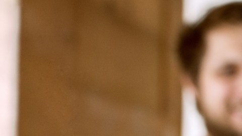 Imagen de dos personas en un segundo plano que sostienen la llave de una vivienda en las manos.