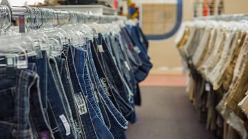 Imagen de un rack con ropa de segunda mano, en medio de una tienda.