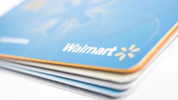 Imagen de una tarjeta de la marca Walmart en color azul, colocada sobre otras tarjetas de varios colores.