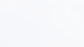 Imagen de una estación de carga para vehículos eléctricos y de un automóvil de la marca Tesla, de color gris.