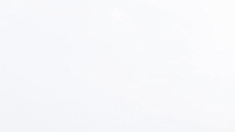 Imagen de una estación de carga para vehículos eléctricos y de un automóvil de la marca Tesla, de color gris.