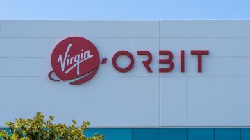 Imagen de un edifico de oficinas de la compañía Virgin Orbit, con el logotipo de la empresa en color rojo.