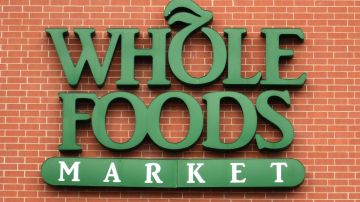 Imagen de un moro de ladrillos rojos en el que se ve un logotipo de la marca Whole Foods en color verde.