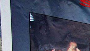 Una mujer camina junto a un cartel que ofrece recompensas de hasta cinco millones de dolares, por informacion que conduzca a la detención de miembros del Cártel de Sinaloa. / Foto: AFP/Getty Images