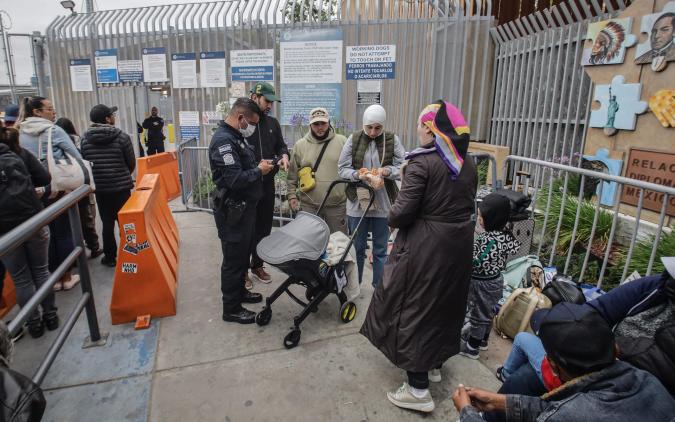 MEX6409. TIJUANA (MÉXICO), 30/05/2023.- Migrantes de diferentes nacionalidades esperan en la entrada de la garita peatonal de San Ysidro para solicitar asilo a las autoridades estadounidenses, el 29 de mayo de 2023, en Tijuana (México). Medio centenar de migrantes improvisó un campamento en las inmediaciones de la garita de San Ysidro, en la ciudad mexicana de Tijuana, fronteriza con Estados Unidos, donde piden atención de las autoridades estadounidenses para solicitar asilo humanitario. EFE/Joebeth Terríquez