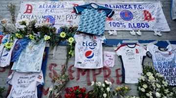 Fotografía de camisetas y flores hoy en un homenaje a los aficionados fallecidos tras una estampida humana durante un partido en El Salvador.