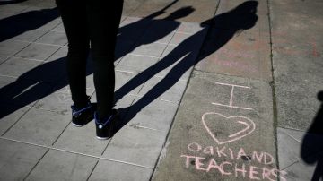 OAKLAND, CALIFORNIA - FEBRUARY 21: An Oakland Unified School District student stands next to a message written in chalk as teachers picket outside of Oakland Technical High School on February 21, 2019 in Oakland, California. Nearly 3,000 teachers in Oakland have gone on strike and are demanding a 12 percent retroactive raise. (Photo by Justin Sullivan/Getty Images)