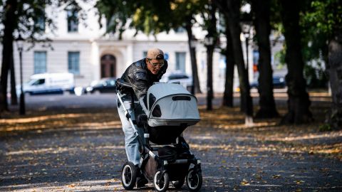 A man walks his baby in a baby stroller at Humlegarden in Stockholm on September 24, 2020. - While France has just increased paternity leave to 28 days, in Sweden, a pioneer in gender equality, parents share 480 days off, which can be taken until the child's 12th birthday at 80% of the salary for the first 390 days and fathers have a minimum of three months, but only half of them take full advantage of it. (Photo by Jonathan NACKSTRAND / AFP) (Photo by JONATHAN NACKSTRAND/AFP via Getty Images)