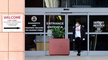 A woman steps out of the Emergency section at LAC+USC Hospital in Los Angeles, California on December 8, 2020 as the coronavirus pandemic rages across the southern California population. - More than 8,000 new Covid-19 cases and another record for hospitalization was reported for Los Angeles County on December 7, 2020 as a spike in infections of health care workers puts additional staffing pressure on medical centers dealing with the coronavirus pandemic. (Photo by Frederic J. BROWN / AFP) (Photo by FREDERIC J. BROWN/AFP via Getty Images)