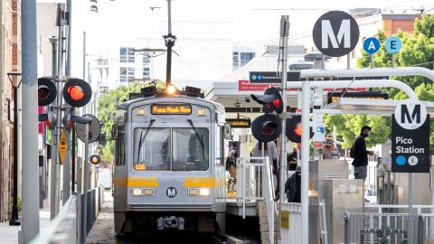 A woman wearing a face mask drives a Metro line train in the downtown area on March 8, 2021 in Los Angeles, California. (Photo by VALERIE MACON / AFP) (Photo by VALERIE MACON/AFP via Getty Images)