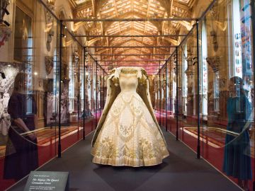 WINDSOR, ENGLAND - JULY 06: Continuing the Platinum Jubilee celebrations in this historic year, her Majesty's Coronation dress, designed by Sir Norman Hartnell and embroidered with an iconographic scheme of emblems representing Commonwealth states and the United Kingdom and the Robe of Estate, worn by Her Majesty at her Coronation, made of purple silk and velvet, and measuring 6.5m in length, are displayed as part of a special display at Windsor Castle exploring the Coronation of Queen Elizabeth II in 1953, at Windsor Castle on July 6, 2022 in Windsor, England. (Photo by Nicky J Sims/Getty Images)