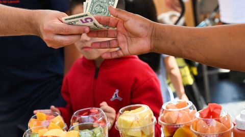 A customer pays cash for a container of fresh fruit from a street vendor along Hollywood Blvd on July 13, 2022 in Los Angeles, California. - US consumer price inflation surged 9.1 percent over the past 12 months to June, the fastest increase since November 1981, according to government data released on July 13. Driven by record-high gasoline prices, the consumer price index jumped 1.3 percent in June, the Labor Department reported. (Photo by Patrick T. FALLON / AFP) (Photo by PATRICK T. FALLON/AFP via Getty Images)