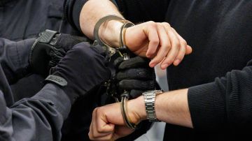 A defendant is led in handcuffs by judicial officers into the courtroom of the Higher Regional Court in Dresden, eastern Germany on January 27, 2023 before a hearing in the trial over a jewellery heist on the Green Vault (Gruenes Gewoelbe) museum in Dresden's Royal Palace in November 2019. - Six members of a notorious criminal gang are on trial in Germany over the spectacular heist in which 18th-century jewels were snatched from the state museum in Dresden. They are accused of gang robbery and arson after the brazen night raid on The Green Vault museum on November 25, 2019. In a previous hearing, three members of the gang had confessed to stealing the jewels. (Photo by JENS SCHLUETER / POOL / AFP) (Photo by JENS SCHLUETER/POOL/AFP via Getty Images)
