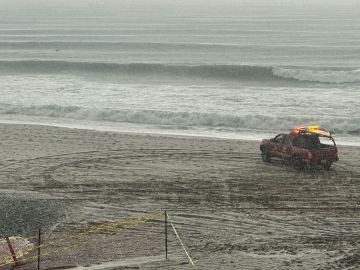 A Los Angeles County Lifeguard vehicle drives on the beach as hail and rain fall during a winter storm that blanketed the region in Redondo Beach, California, on February 25, 2023. - Heavy snow fell in southern California as the first blizzard in a generation pounded the hills around Los Angeles, with heavy rains threatening flooding in other places. (Photo by Patrick T. Fallon / AFP) (Photo by PATRICK T. FALLON/AFP via Getty Images)