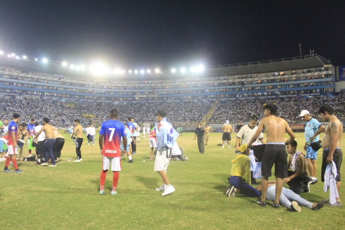 Fans dentro del terreno de juego tras estampida en El Salvador. GABRIEL AQUINO/AFP via Getty Images).