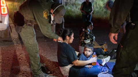 Un médico de CBP coloca una compresa fría en el cuello de una inmigrante que sufre de agotamiento por calor.