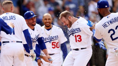 Max Muncy es recibido en el home por sus compañeros tras el bombazo de cuatro carreras en la novena entrada.