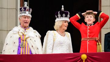 El rey Carlos III y la reina consorte Camila junto a uno de los nietos de ella en el balcón real.