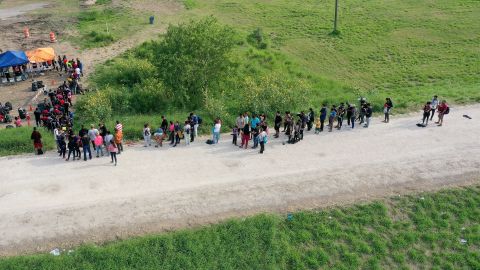 Inmigrantes esperan ser procesados por CBP después de cruzar la frontera el 10 de mayo de 2023 en Texas.