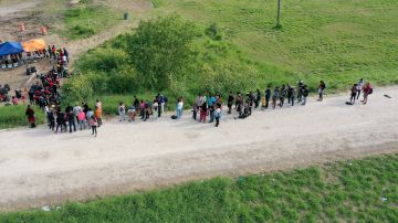 Inmigrantes esperan ser procesados por CBP después de cruzar la frontera el 10 de mayo de 2023 en Texas.