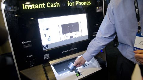 A technology representative demonstrates the ecoATM which purchases used cellphones from consumers during CES on the Hill on Capitol Hill in Washington, DC, on April 16, 2013. The Consumer Electronics Association organized demonstrations by technology companies to discuss economic innovation and show their latest products to elected officials and Congressional staffers. AFP PHOTO / Saul LOEB (Photo credit should read SAUL LOEB/AFP via Getty Images)