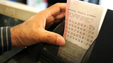 RUSSELL, IL - NOVEMBER 10: The hand of Sukhjit S. Toor reaches for printed Mega Millions lottery tickets at a gas station which is located on the border of the state of Wisconsin November 10, 2005 in Russell, Illinois. Lotto players are looking to get their tickets for Friday's Mega Millions drawing which is currently at $262 million. Mega Millions is not played in Wisconsin as players drive into Illinois for their chance at the winnings. The game is also played in Georgia, Illinois, Maryland, Massachusetts, Michigan, New Jersey, New York, Ohio, Texas, Virginia, California and Washington. (Photo by Tim Boyle/Getty Images)