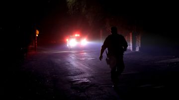 SONOMA, CA - OCTOBER 11: A California Highway Patrol walks in the middle of the street as he goes door-to-door to ask residents to voluntarily evacuate as a wildfire approaches on October 11, 2017 in Sonoma, California. Twenty one people have died in wildfires that have burned tens of thousands of acres and destroyed over 3,000 homes and businesses in several Northen California counties. (Photo by Justin Sullivan/Getty Images)