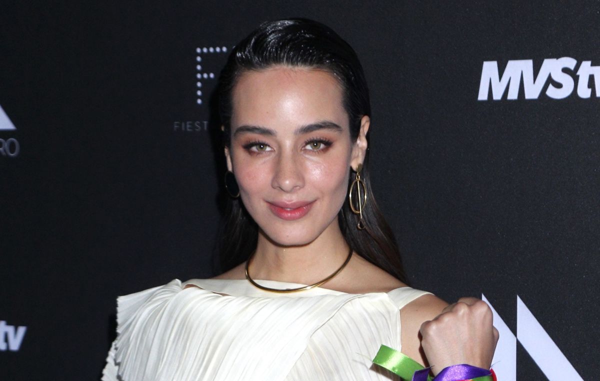 Esmeralda Pimentel poses in profile and covers her body only with a coat