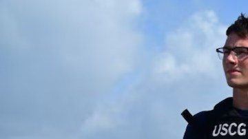 Un miembro de la Guardia Costera custodia las drogas incautadas mientras se descargan en Miami.