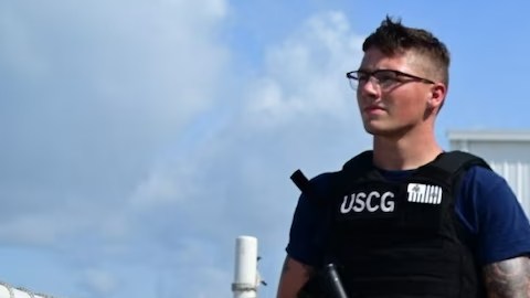 Un miembro de la Guardia Costera custodia las drogas incautadas mientras se descargan en Miami.