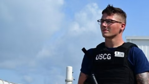 Un miembro de la Guardia Costera custodia las drogas incautadas mientras se descargan en Miami.