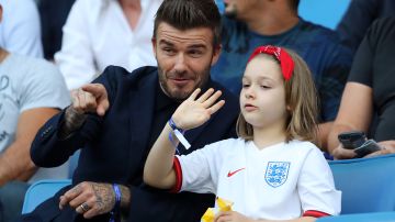 David Beckham junto a su hija Harper en un partido de fútbol.