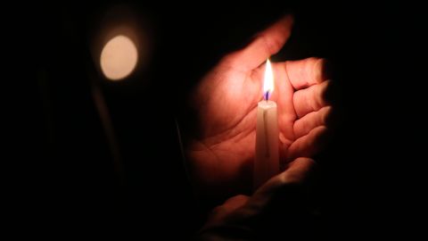 A mourner holds a candle at the synagogue in Halle and der Saale, eastern Germany, on October 10, 2019 one day after the deadly anti-Semitic shooting. - Two people were shot dead in the eastern German city of Halle on October 9, 2019, with a synagogue as the prime target on Yom Kippur. The suspect, 27-year-old German Stephan Balliet, filmed the assault and live-streamed it. (Photo by Ronny Hartmann / AFP) (Photo by RONNY HARTMANN/AFP via Getty Images)