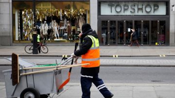 A street cleaner walks past a closed-down Topshop clothes store, operated by Arcadia, on Oxford Street in central London on November 27, 2020. British fashion empire Arcadia, which owns Topshop stores, announced Friday it was evaluating several "rescue options" to save its brands after media reports suggested an imminent bankruptcy attributed to the coronavirus pandemic. Bankruptcy of the group, which has 15,000 employees and more than 500 stores, would be a thunderclap in British commerce, already hit hard by the health crisis and the rise in online shopping. (Photo by Tolga Akmen / AFP) (Photo by TOLGA AKMEN/AFP via Getty Images)