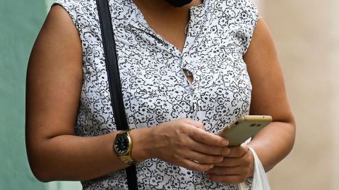 Mujer caminando con celular en mano