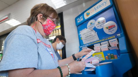 A woman picks numbers for her Mega Millions lottery tickets at a 7-Eleven convenience store in Chino Hills, California on July 28, 2022. - The odds of claiming this week's bonanza US lottery prize are less than one-in-300-million -- but one "lucky" convenience store outside Los Angeles is already counting its winnings. A sign above the counter of the otherwise unassuming shop in California's Chino Hills proclaims itself the "LUCKIEST 7-ELEVEN IN THE WORLD," six years after it sold a winning ticket for the largest jackpot in US lottery history. (Photo by RINGO CHIU / AFP) (Photo by RINGO CHIU/AFP via Getty Images)