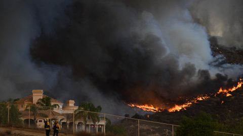 TOPSHOT - Plumes of smoke rise as wildfire approaches a home during the Fairview Fire near Hemet, California in Riverside County on September 7, 2022. - A ferocious heat wave scorching the western United States could finally begin to wane in the coming days, forecasters said on September 7, but they warned of dangerous fire conditions as howling winds sweep through the bone-dry region. (Photo by Patrick T. FALLON / AFP) (Photo by PATRICK T. FALLON/AFP via Getty Images)