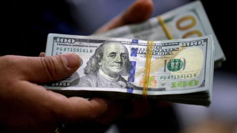 An employee counts banknotes at currency exchange shop in Baghdad on February 14, 2023. - Iraq nudged up the value of its local currency against the dollar in an effort to stabilise the dinar after tougher foreign transfer regulations sent its value fluctuating. The government adopted a new official exchange rate, fixing it at 1,300 dinars to the US dollar instead of 1,470, the prime minister's office said. (Photo by Murtaja LATEEF / AFP) (Photo by MURTAJA LATEEF/AFP via Getty Images)