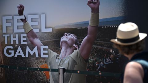 A visitor walks past a poster featuring Spanish tennis player rafael Nadal during the Media Day of the Roland-Garros Open tennis tournament in Paris on May 27, 2023. (Photo by Emmanuel DUNAND / AFP) (Photo by EMMANUEL DUNAND/AFP via Getty Images)