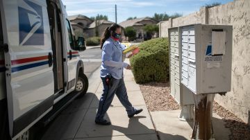 PHOENIX, ARIZONA - OCTOBER 08: U.S. Postal Service letter carrier Dawnya Allred delivers mail, including yellow mail-in ballots to a residential neighborhood on October 08, 2020 in Phoenix, Arizona. Postal authorities are expecting a record number of mail-in ballots this year due to the coronavirus pandemic. (Photo by John Moore/Getty Images)