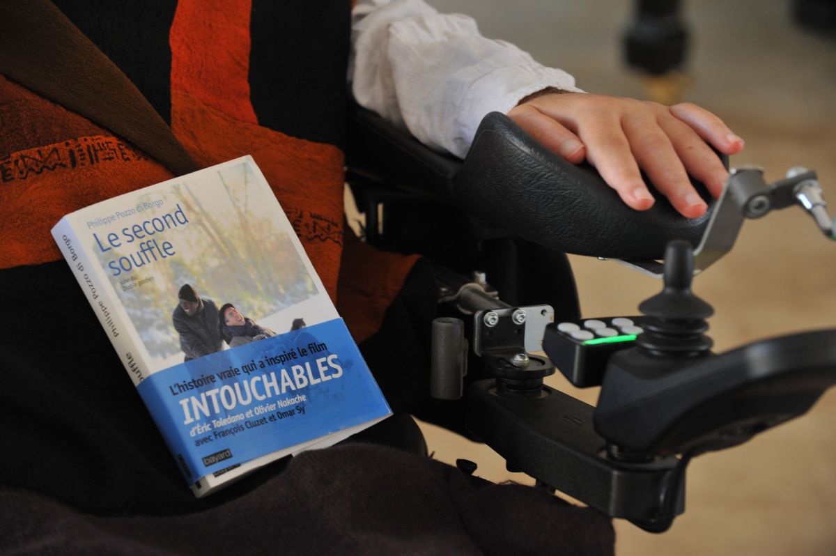 El empresario, escritor y tetrapléjico francés superviviente de un accidente de parapente Philippe Pozzo di Borgo posa con su libro en su residencia de Essaouira el 17 de diciembre de 2011.