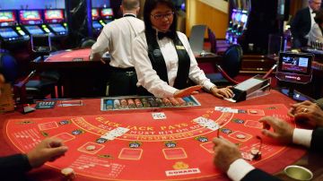 Passengers play Black Jack at the casino aboard the British cruise liner RMS Queen Mary 2 on June 27, 2017 as it sails in the Atlantic ocean during The Bridge 2017, a transatlantic race between the Queen Mary 2 and the world's fastest Ultim trimarans from Saint-Nazaire to New-York City. "The Bridge 2017" is a 3,152-mile (5,837 km) race between the British cruise liner RMS Queen Mary 2 and four trimarans, from Saint-Nazaire to New-York City. (Photo by LOIC VENANCE / AFP) (Photo by LOIC VENANCE/AFP via Getty Images)