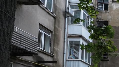 Un coche destrozado frente a un edificio de apartamentos dañado tras un atentado.