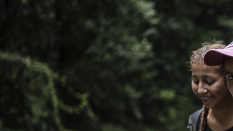 Migrantes cruzan un río mientras cruzan el Tapón del Darién de Colombia a Panamá,