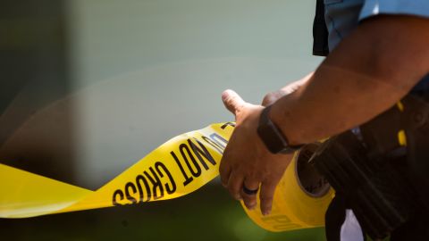 MINNEAPOLIS, MN - JUNE 16: A Minneapolis Police officers unrolls caution tape at a crime scene on June 16, 2020 in Minneapolis, Minnesota. The Minneapolis Police Department has been under increased scrutiny by residents and elected officials after the death of George Floyd in police custody on May 25. (Photo by Stephen Maturen/Getty Images)