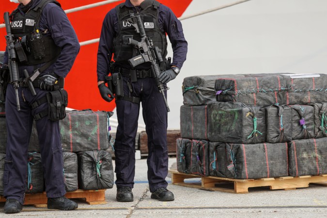 US Coast Guard personnel stand guard over bundles of seized drugs in front of the Cutter Bertholf on September 10, 2020 in San Diego, California. - The crew seized more than 26,00 pounds of cocaine and marijuana from suspected drug smugglers in the Eastern Pacific Ocean. (Photo by SANDY HUFFAKER / AFP) (Photo by SANDY HUFFAKER/AFP via Getty Images)