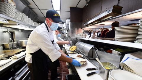 In this photo taken on June 15, 2021 kitchen staff continue wearing facemasks while preparing breakfast at Langer's Delicatessen-Restaurant in Los Angeles, California, on California's first day of fully reopening its economy after some fifteen months of Coronavirus pandemic restrictions. - California state regulators on June 17, 2021 have approved revised workplace pandemic rules ending most mask requirements for employees vaccinated againt the coronavirus. (Photo by Frederic J. BROWN / AFP) (Photo by FREDERIC J. BROWN/AFP via Getty Images)