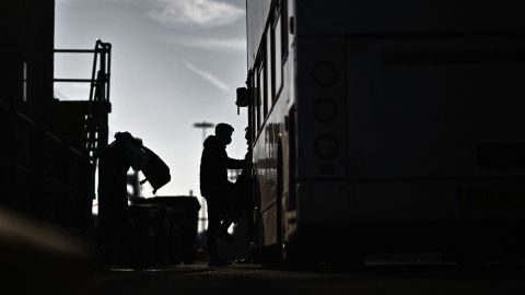 TOPSHOT - Migrants, picked up at sea while attempting to cross the English Channel, get into a bus to be taken for processing, after disembarking from a UK Border Force boat at the Marina in Dover, on the south-east coast of England, on April 18, 2022. (Photo by Ben Stansall / AFP) (Photo by BEN STANSALL/AFP via Getty Images)