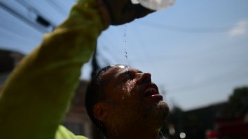 PHILADELPHIA, PA - AUGUST 4: Construction worker Felipe Campuzano pours water on his face to cool off as he digs a sanitation pipe ditch during a heatwave on August 4, 2022 in Philadelphia, Pennsylvania. Heat advisories are in place across much of the Northeast as temperatures exceed 100 degrees. (Photo by Mark Makela/Getty Images)